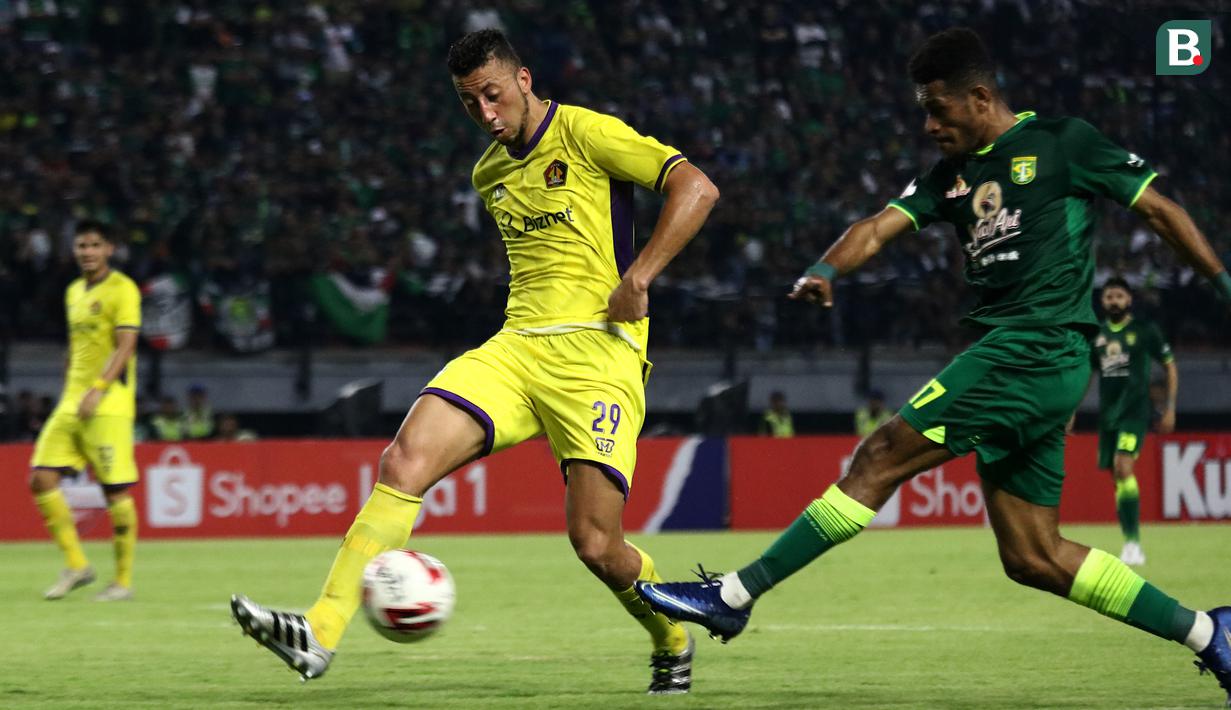 Bek Persik Kediri, Jefferson Oliviera, berebut bola dengan pemain Persebaya, Ricky Kambuaya, pada laga pembuka Shopee Liga 1 2020, Sabtu (29/2). Persebaya dan Persik bermain imbang 1-1. (Bola.com/Aditya Wany)
