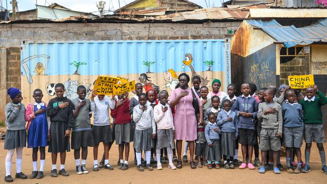 Para murid sekolah dasar Kenya memegang plakat untuk mengekspresikan dukungan kepada China di Nairobi, ibu kota Kenya, pada 19 Februari 2020. Banyak anak di seluruh dunia membuat lukisan sebagai wujud solidaritas terhadap perjuangan China memerangi epidemi coronavirus baru. (Xinhua/Li Yan)