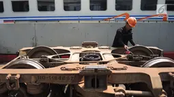Petugas melakukan perbaikan pada gerbong kereta api di Depo Kereta Poncol Semarang, Kamis (31/5). PT Kereta Api Indonesia sudah bersiap-siap menyambut arus mudik dan arus balik lebaran dengan mempersiapkan armadanya. (Liputan6.com/Gholib)