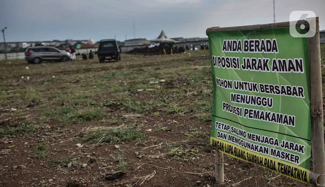 Spanduk tanda batas keluarga menyaksikan pemakaman di TPU Rorotan, Jakarta, Minggu (28/3/2021). Hingga hari ini sudah ada 9 jenazah pasien Covid-19 dimakamkan di TPU Rorotan yang berkapasitas 1.500 petak makam tersebut. (merdeka.com/Iqbal S. Nugroho)
