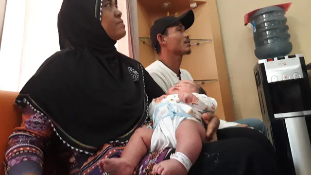 Bayi raksasa nyaman dalam gendongan Mbah Uti-nya. (Foto: Liputan6.com/Muhamad Ridlo)