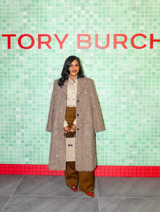 Mindy Kaling mengenakan koleksi Fall/Winter 2024 Look 2 Sequined Coat, dan the Striped Poplin Shirt, Wool Twill Pant, Pierced XL Pump, Lee Radziwill Sublime Shopper Tote, serta Eleanor Oversized Metal Square Sunglasses.  [Dok/Tory Burch].