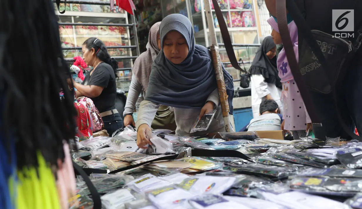Seorang anak memilih kaus kaki untuk keperluan sekolah di Pasar Asemka, Jakarta, Selasa (7/9/2019). Jelang dimulainya tahun ajaran baru, Pasar Asemka ramai dikunjungi warga untuk berbelanja keperluan sekolah. (Liputan6.com/Helmi Fithriansyah)