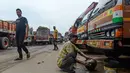 Seorang sopir mencuci di samping sebuah truk yang diparkir di sebuah terminal di Chennai (19/9/2019). Akibat pemogokan layanan transportasi, beberapa sekolah di ibukota nasional akan diliburkan saat pemogokan satu hari tersebut. (AFP Photo/Arun Sankar)