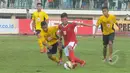 Pemain depan Timnas U-16, Riski Fajar berusaha melewati pemain Semen Padang U-16 pada laga uji coba di Stadion Singaperbangsa, Jawa Barat, Senin (9/3/2015). Timnas U-16 bermain imbang 4-4 dengan Semen Padang U-16. (Liputan6.com/Herman Zakharia)