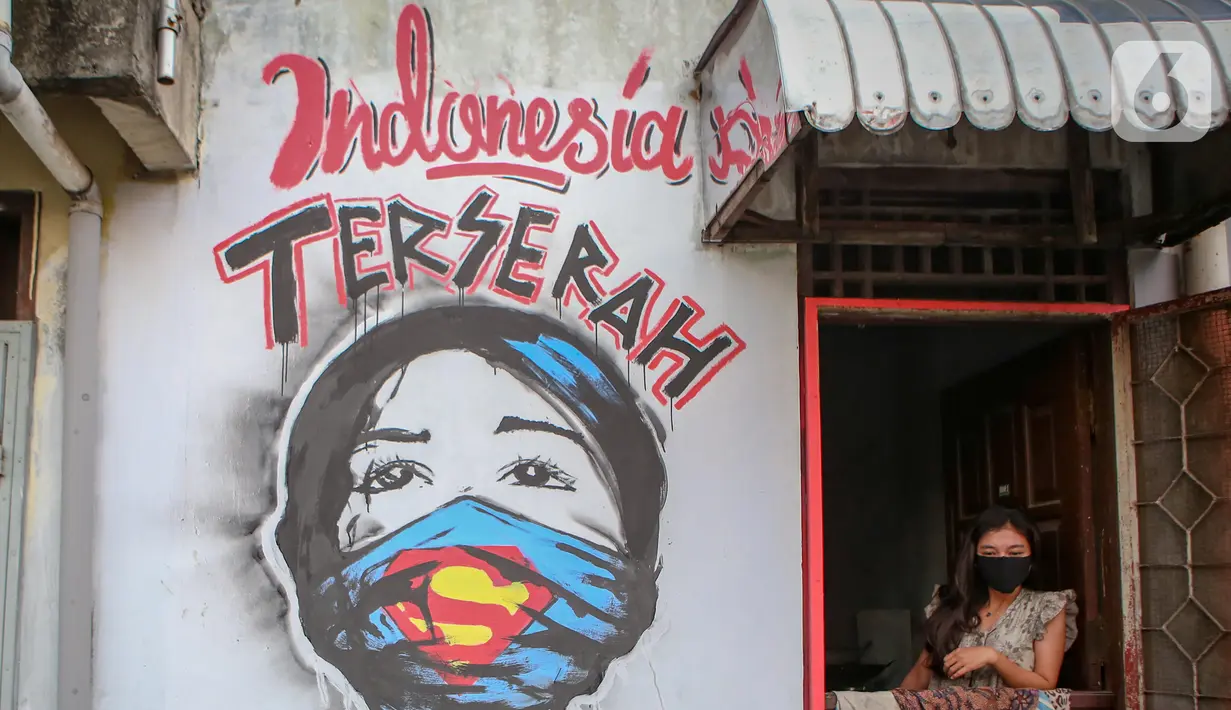 Warga berada di dekat mural bertuliskan "Indonesia terserah", di Kutabumi, Tangerang, Banten, Senin (27/5/2020). Mural dibuat sebagai bentuk kritik terhadap masyarakat yang tetap beraktivitas di luar ruangan tanpa prosedur protokol kesehatan di tengah wabah COVID-19. (Liputan6.com/Angga Yuniar)