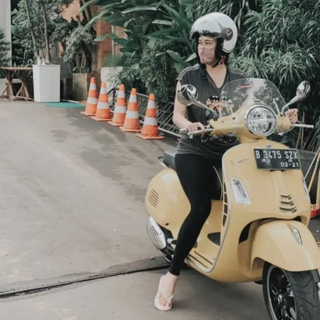 Aura Kasih saat naik Vespa