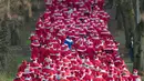 Para peserta mengenakan kostum Santa Claus berpartisipasi dalam Santa Claus Run di Michendorf, Jerman timur, Minggu (10/12). Kegiatan amal yang digelar setiap tahun ini diikuti ribuan warga Jerman dan wisatawan mancanegara. (Ralf Hirschberger/dpa via AP)