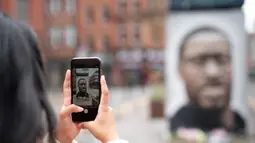 Seseorang mengabadikan foto mural George Floyd di Manchester tengah, Inggris (4/6/2020). George Floyd tewas kehabisan napas saat dalam penahanan pihak kepolisian Negara Bagian Minnesota, wilayah Midwest Amerika Serikat, pada pekan lalu. (Xinhua/Jon Super)