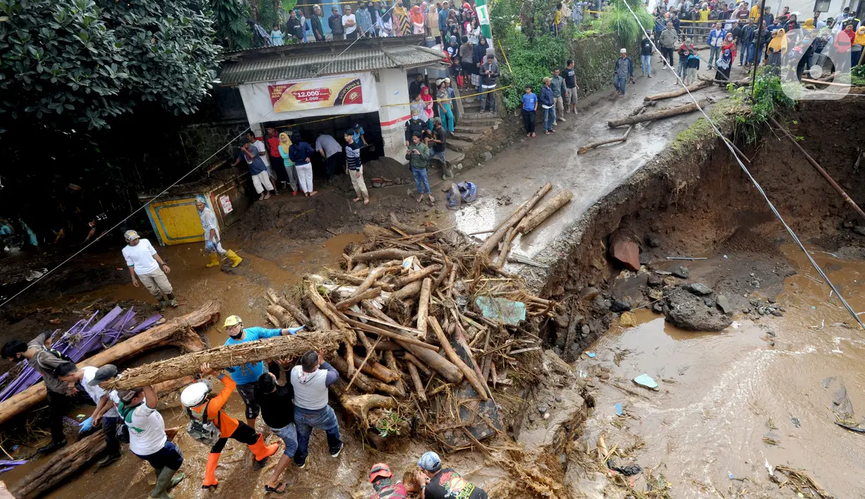 Tim SAR gabungan TNI, Polri, dan relawan membersihkan material longsor usai banjir bandang menerjang Kampung Cibuntu, Desa Pasawahan, Kecamatan Cicurug, Sukabumi, Selasa (22/9/2020). Banjir mengakibatkan puluhan bangunan rusak berat, 12 rumah hanyut, dan dua korban hilang. (merdeka.com/Arie Basuki)