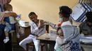 Seorang siswa bereaksi saat menerima vaksin virus corona COVID-19 Sinovac di sebuah sekolah dasar di Darul Imarah, Kabupaten Aceh Besar, Provinsi Aceh, 14 Januari 2022. (CHAIDEER MAHYUDDIN/AFP)