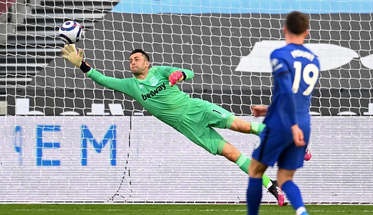 Kiper West Ham United, Lukasz Fabianski melakukan penyelamatan saat melawan Chelsea dalam laga lanjutan Liga Inggris 2020/2021 pekan ke-33 di The London Stadium, London, Sabtu (24/4/2021). West Ham kalah 0-1 dari Chelsea. (AFP/Andy Rain/Pool)