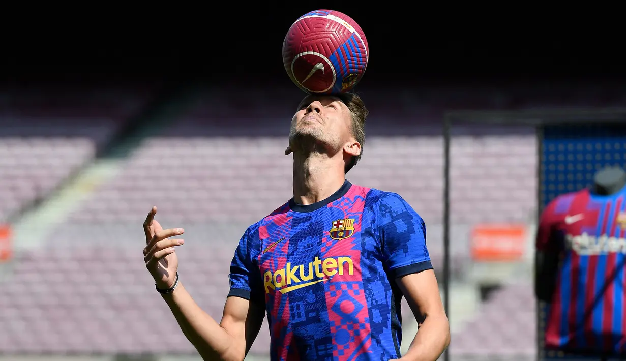 Pesepak bola asal Belanda Luuk de Jong bermain dengan bola saat diperkenalkan sebagai rekrutan baru Barcelona, di stadion Camp Nou di Barcelona, Kamis (9/9/2021). De Jong merupakan pemain yang dimiliki Sevilla sebelum bergabung bersama Barcelona. (Josep LAGO / AFP)