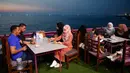 Keluarga Palestina menikmati makanan di sebuah restoran di sepanjang pantai di Kota Gaza (10/6/2019). Pergi ke restoran di dekat pantai merupakan opsi bagi warga Palestina untuk menikmati suasana alam. (AFP Photo/Mohammed Abed)