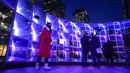 Orang-orang memotret "Emergence" oleh This Is Loop, sebagai bagian dari festival Winter Lights di Canary Wharf, di London, Rabu (18/1/2023). Festival Winter Lights kembali ke Canary Wharf untuk pertama kalinya sejak 2020. (AP Photo/Alberto Pezzali)