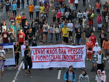 Relawan Komunitas Peduli ASEAN melakukan aksi di jalan MH Thamrin, Jakarta, Minggu (13/3/2016). Relawan ini mengajak masyarakat menggunakan kaos bergambar tentang ke-Indonesia-an dan memposting ke seluruh media sosial. (Liputan6.com/Helmi Fithriansyah)
