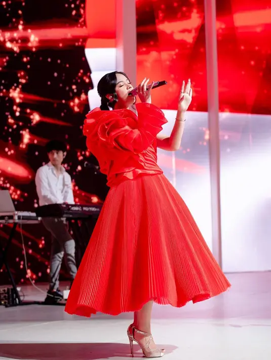 Inspirasi tampil di acara Natal dan Tahun Baru dengan luar biasa? Lihat bagaimana penampilan Lyodra dalam balutan asymmetrical gown berwarna merah ini. Foto: Instagram.