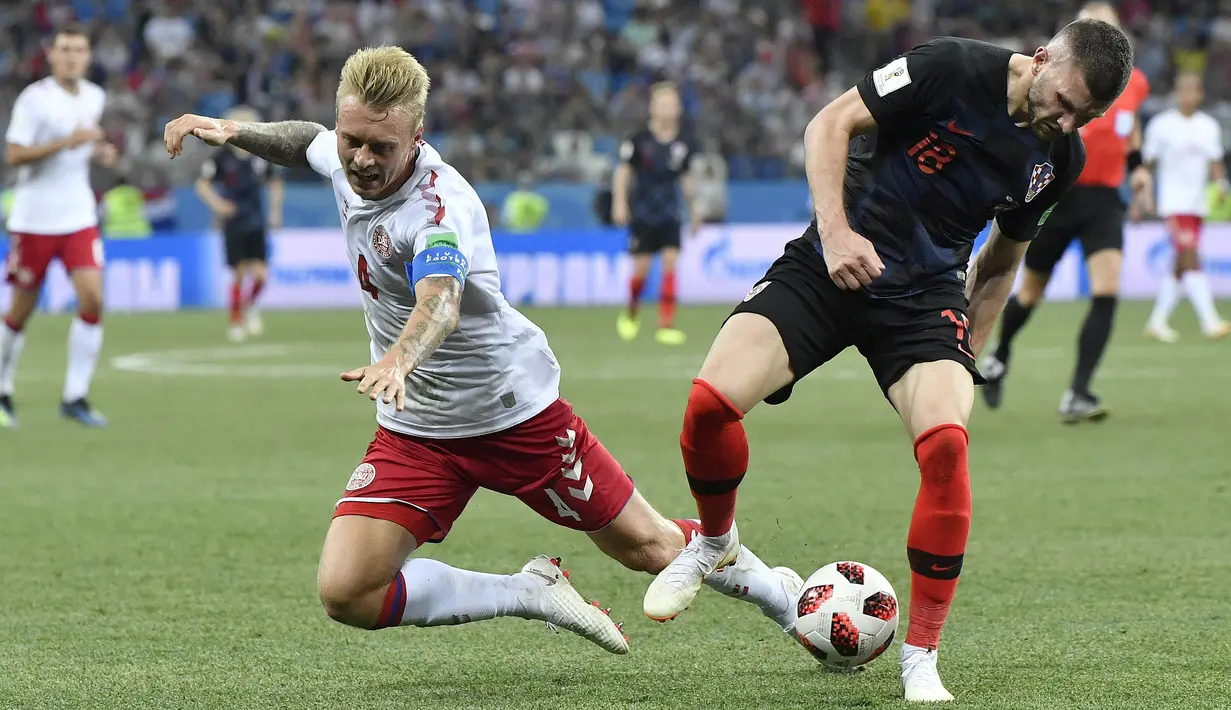 Pemain Denmark, Simon Kjaer (kiri) berebut bola dengan pemain Kroasia, Ante Rebic pada laga 16 besar Piala Dunia 2018 di Nizhny Novgorod Stadium, Rusia, (1/7/2018). Kroasia menang 3-2 lewat adu penalti. (AP/Martin Meissner)