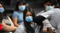 Seorang perawat menginokulasi seorang remaja wanita dengan dosis booster vaksin Pfizer melawan COVID-19 di Mexico City (9/2/2022). Menteri kesehatan Meksiko melaporkan 9.242 kasus baru COVID-19 dan 206 kematian pada Senin (7/2/2022). (AFP/Claudio Cruz)