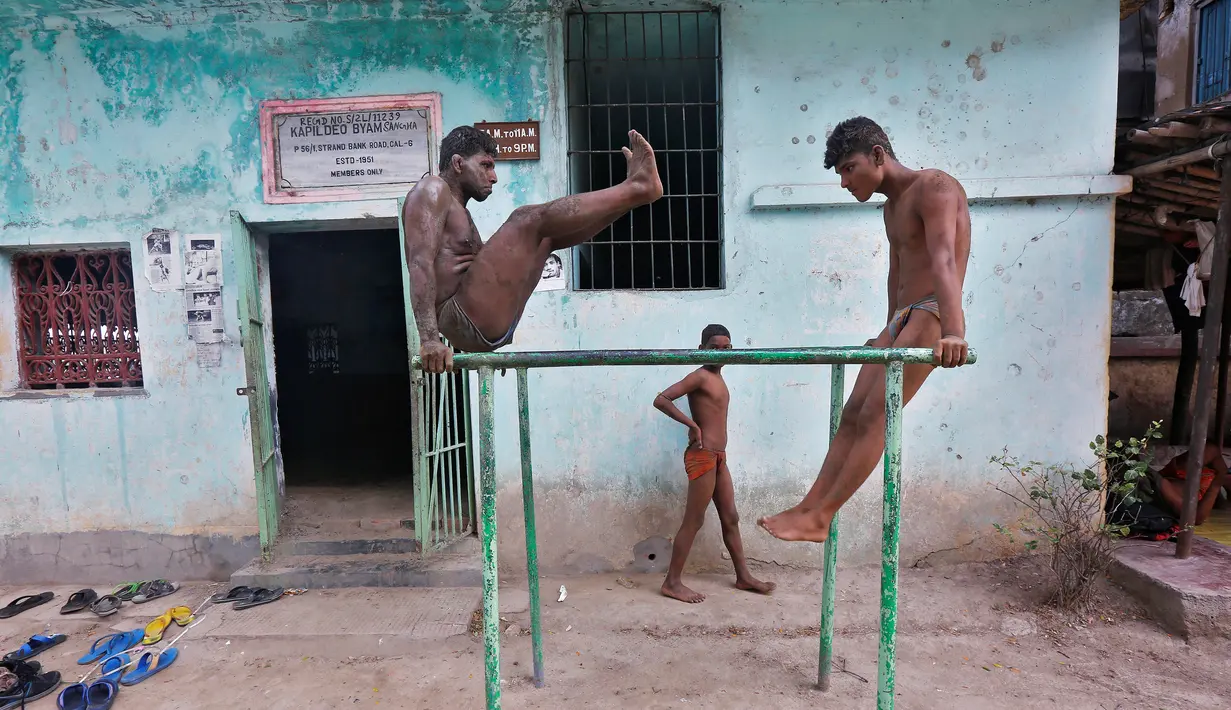 Dua pegulat saat berlatih di batang besi di pusat pelatihan gulat tradisional India di tepi Sungai Gangga menjelang Bengal kejuaraan gulat lumpur, di Kolkata, India 17 Mei 2016. (REUTERS / Rupak De Chowdhuri)