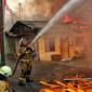 Petugas pemadam kebakaran berusaha memadamkan api saat terjadi kebakaran di kawasan padat penduduk di Jalan Simprug Golf II RT 4/8, Grogol Selatan, Kebayoran Lama, Jakarta Selatan, Minggu (21/8/2022). Belum diketahui penyebab kebakaran yang membakar puluhan rumah tersebut. (Liputan6.com/Angga Yuniar)