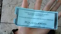 Pengunjung menunjukkan tiket parkir wisata Danau Kerinci saat Lebaran. (Liputan6.com/B Santoso)