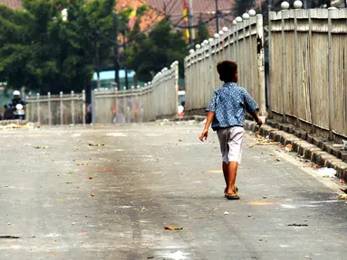Seorang anak melintas di Jalan Jatinegara Barat Jakarta, Kamis (20/8/2015). Jalan Jatinegara Barat ditutup saat penggusuran warga yang tinggal di bantaran Kali Ciliwung di Kampung Pulo, Jakarta Timur. (Liputan6.com/HelmiFithriansyah)