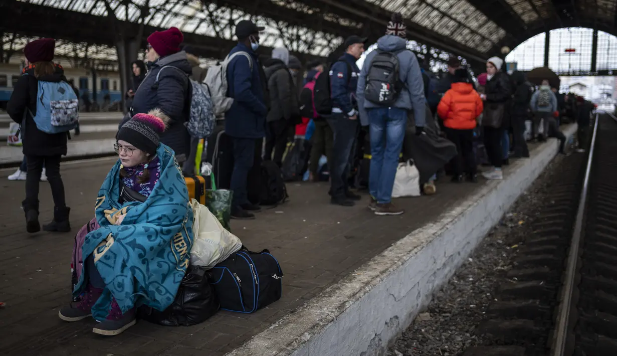 Penumpang menunggu di peron stasiun kereta api Lviv, di Lviv, Ukraina barat pada Minggu, 27 Februari 2022. Dengan mobil, kereta api, dan berjalan kaki, puluhan ribu pengungsi Ukraina mencari keselamatan di negara-negara tetangga Ukraina saat invasi Rusia. (AP Photo/Bernat Armangue)