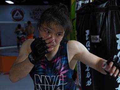 Petarung MMA China Zhang Weili memukul samsak selama sesi pelatihan di gym di Beijing (7/8/2019). Zhang bisa menjadi juara dunia UFC pertama asal China jika dapat mengalahkan pemegang gelar Jessica Andrade dari Brasil dalam pertarungan kelas berat mereka pada 31 Agustus 2019. (AFP Photo/Greg Baker)