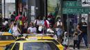 Orang-orang melintas di jalan pada hari pertama masker tidak lagi wajib di Panama City, Panama, Senin (11/7/2022). Masker tidak lagi diperlukan kecuali di rumah sakit dan transportasi umum. (AP Photo/Arnulfo Franco)