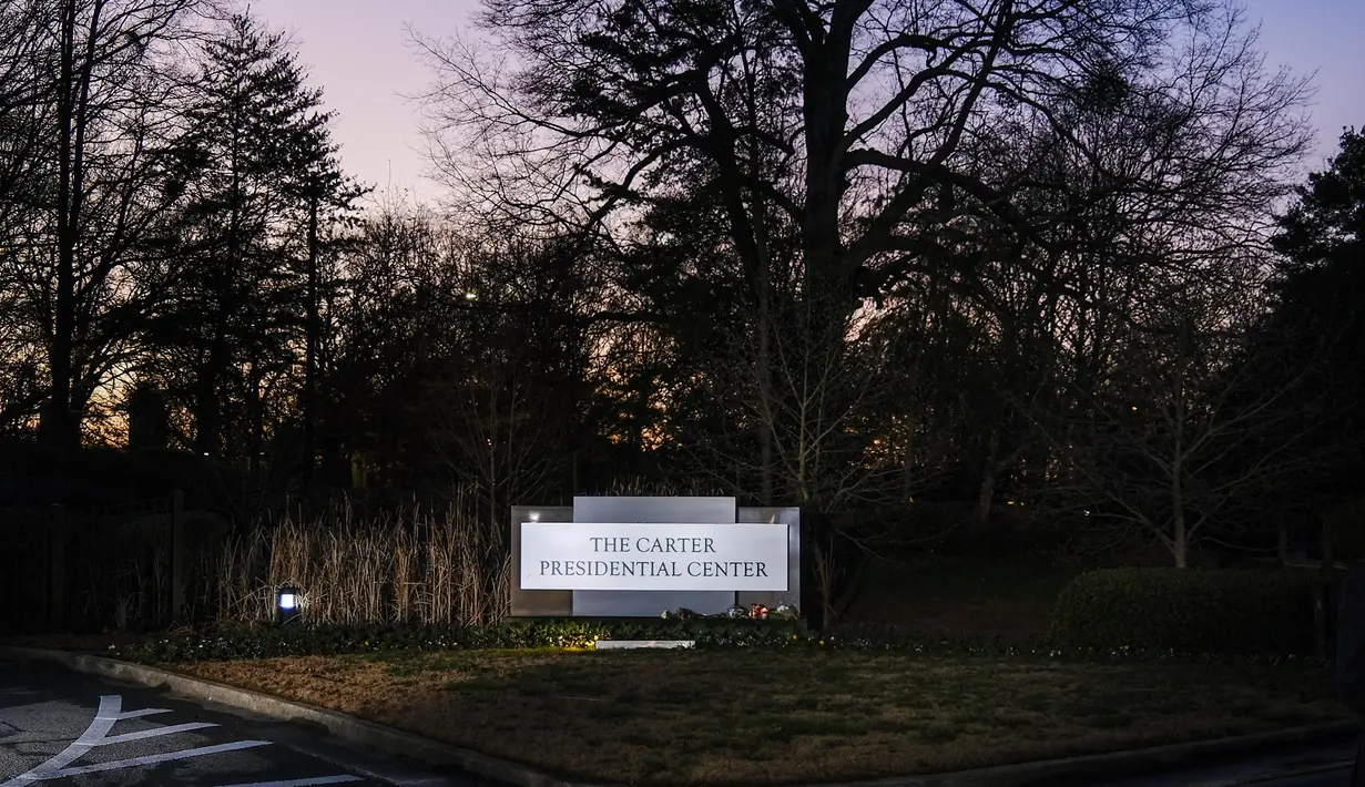 Lilin, bunga, dan kacang diletakkan sebagai penghormatan kepada mantan Presiden AS Jimmy Carter di Carter Presidential Center di Atlanta, Georgia, pada tanggal 29 Desember 2024. (Alex Wroblewski/AFP)