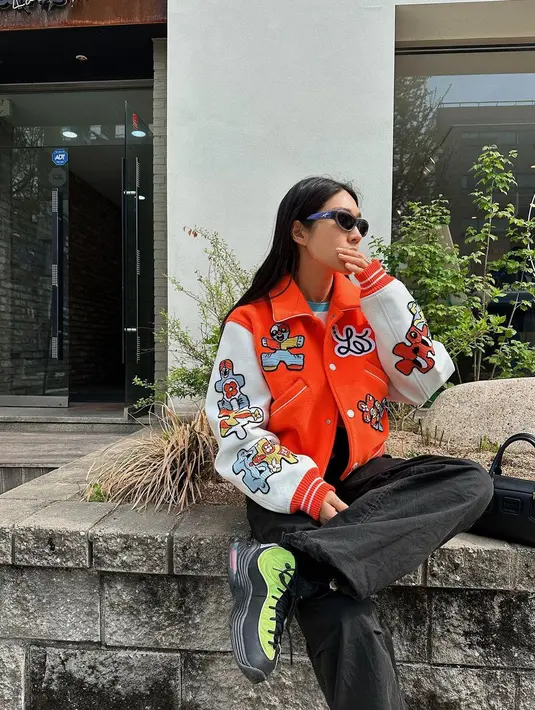Peggy Gou tampil tertutup dengan baseball jacket 2 warna dengan motif yang ramai, dipadunya dengan celana panjang berwarna hitam. [Foto: Instagram/peggygou_]