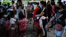 Seorang siswa memeluk penjemputnya di sebuah sekolah umum di Kota Quezon, Filipina pada Rabu (2/11/2022). Jutaan siswa kembali ke sekolah umum di seluruh Filipina saat pemerintah memberlakukan kembali pembelajaran di kelas secara tatap muka setelah lebih dari dua tahun lockdown akibat pandemi virus corona. (AP Photo/Aaron Favila)