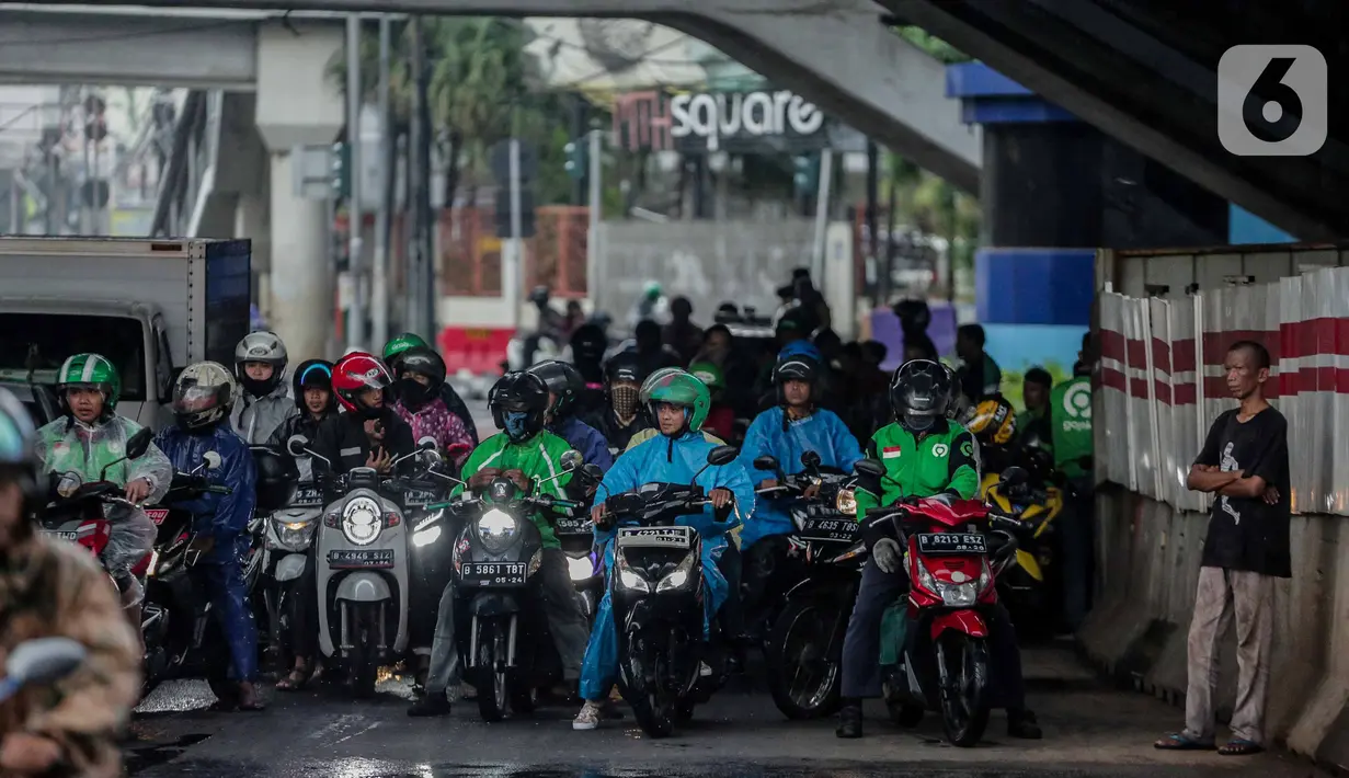 Pengendara sepeda motor memenuhi ruas jalan ketika berteduh di kolong Fly Over Cawang, Jakarta, Selasa (17/12/2019). Perilaku tersebut selain menimbulkan ketidaknyamanan pengguna jalan lainnya, juga memicu kemacetan. (Liputan6.com/Faizal Fanani)