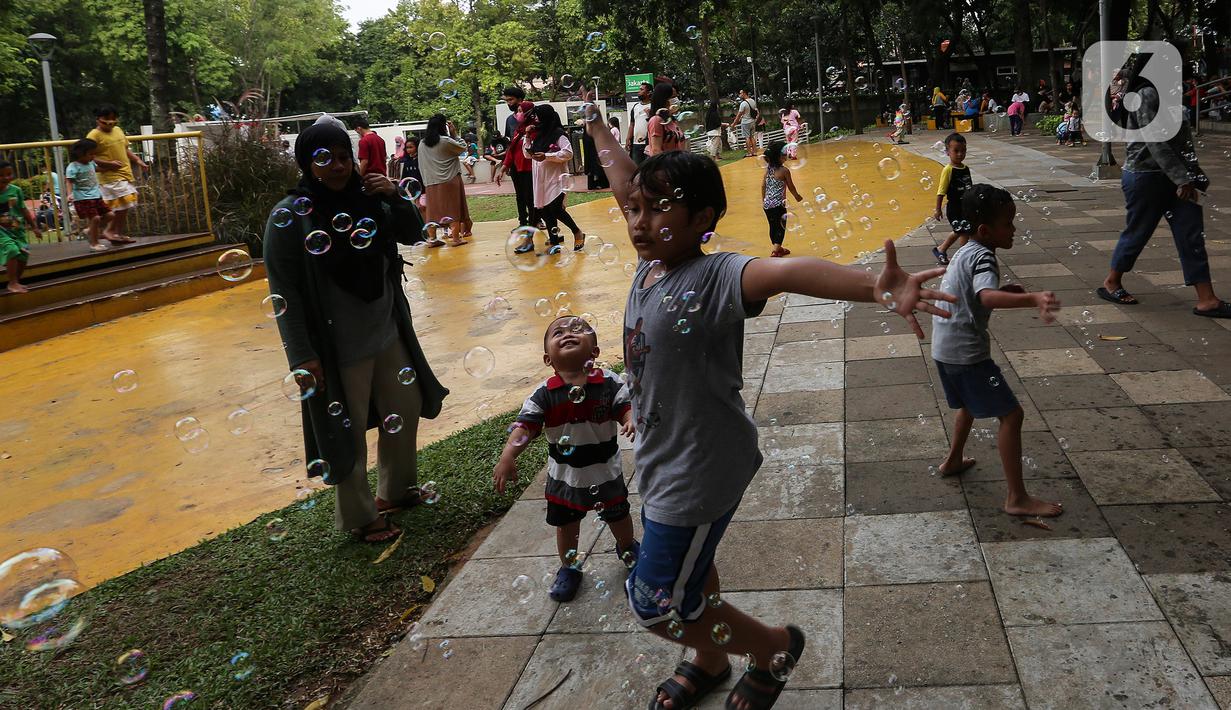Anak-anak bermain gelembung sabun saat menghabiskan waktu di Taman Puring, Jakarta, Minggu (9/1/2022). Di tengah ancaman penyebaran covid-19 varian Omicron dan pemberlakukan PPKM level 2, masyarakat tetap melakukan aktivitas pada akhir pekan di luar rumah. (Liputan6.com/Johan Tallo)