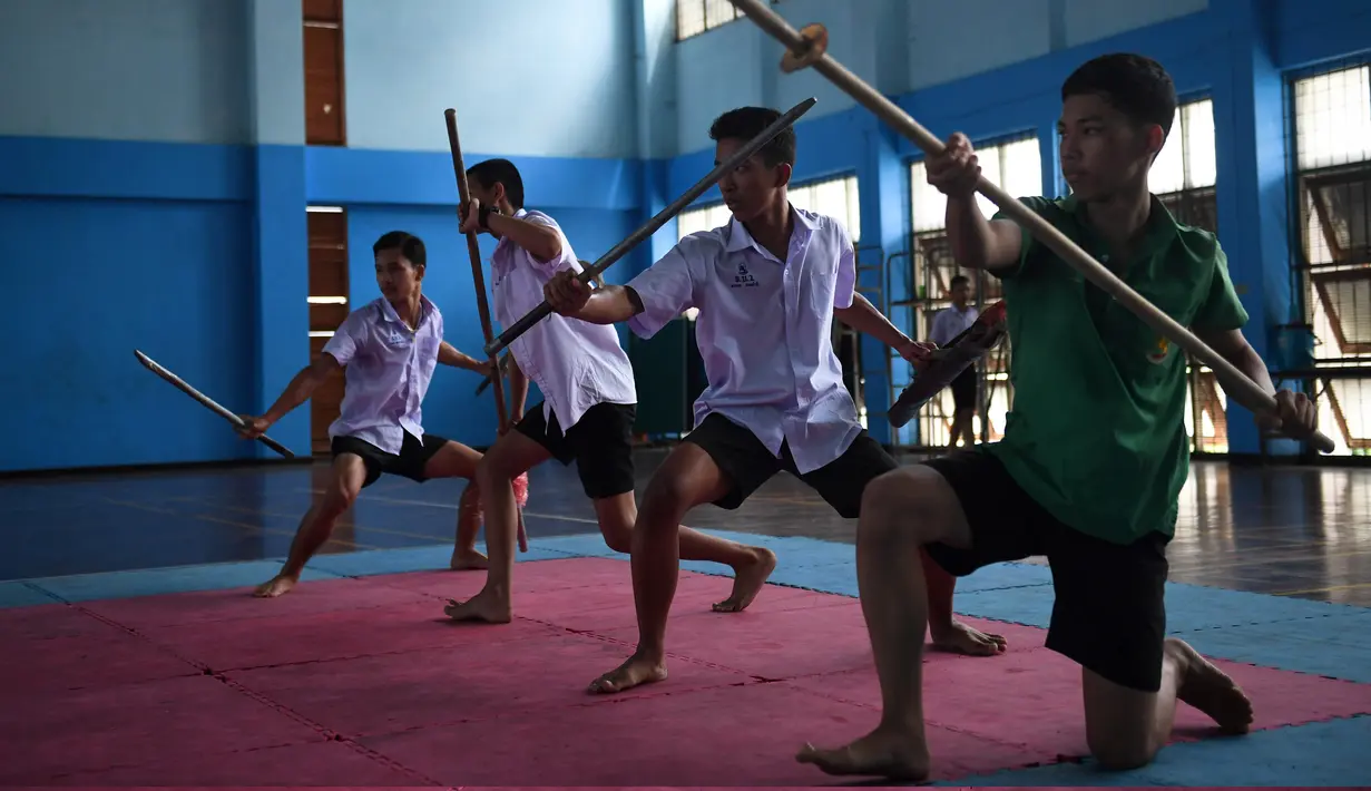 Empat siswa berlatih Krabi Krabong di sekolah Thonburee Woratapeepalarak, Thonburi, Bangkok (8/7/2019). Krabi Krabong merupakan seni bela diri Thailand yang dipersenjatai pisau dan perisai kayu yang terabaikan. (AFP Photo/Lillian Suwanrumpha)
