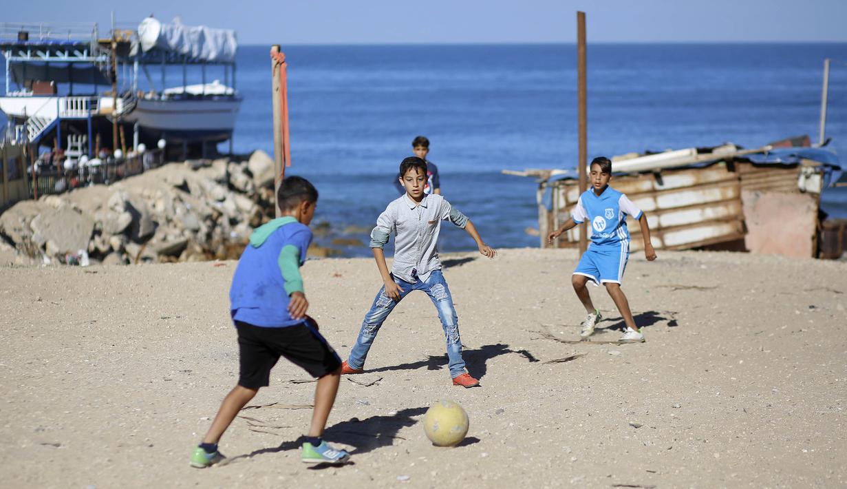 Sejumlah anak Palestina bermain sepak bola di kawasan Gaza, Jumat (3/11/2017). Sepak bola tidak hanya menjadi olahraga favorit, tapi juga sebagai salah satu cara bagi warga untuk mengurangi ketegangan akibat peperangan. (AFP/Mohammed Abed)
