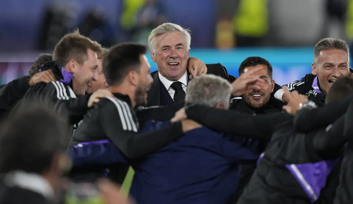 Pelatih Real Madrid, Carlo Ancelotti (tengah) merayakan dengan stafnya setelah memenangkan pertandingan melawan Eintracht Frankfurt pada final Piala Super Eropa di Stadion Olimpiade Helsinki, Finlandia, Kamis (11/8/2022). Real Madrid menang atas Eintracht Frankfurt 2-0. (AP Photo/Antonio Calanni)