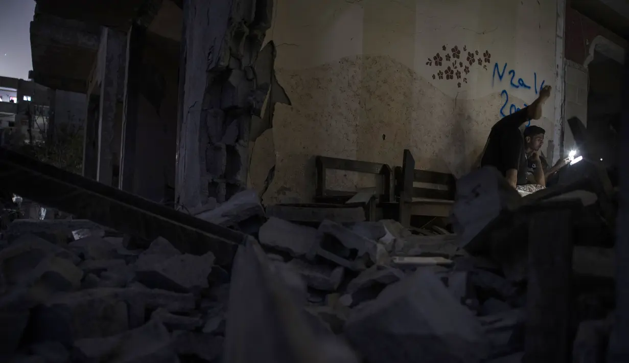Warga Palestina bermalam di samping rumah mereka yang hancur baru-baru ini terkena serangan udara Israel di kota Beit Hanoun, Jalur Gaza utara, Rabu (26/5/2021). Warga Palestina mulai kembali ke rumah mereka yang hancur setelah gencatan senjata diberlakukan dalam perang Gaza. (AP Photo/Khalil Hamra)