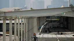 Pekerja menyelesaikan proyek pembangunan jembatan multiguna (skybridge) Tanah Abang di Jakarta, Selasa (9/10). Pembangunan skybridge yang dimulai pada 3 Agustus lalu itu baru mencapai setengah jalan atau 58 persen. (Liputan6.com/Faizal Fanani)