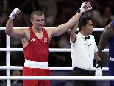 Wasit Indonesia, Muhammad Arisa Putra Pohan saat memimpin pertandingan semifinal tinju Olimpiade Paris 2024 antara petinju Ukraina, Oleksandr Khyzhniak (kiri) melawan petinju Brasil, Wanderley De Souza di North Paris Arena, Villepinte, Prancis, Jumat (02/08/2024). (AP Photo/John Locher)