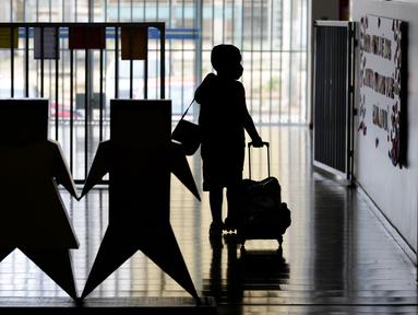 Siswa yang mengenakan masker untuk menahan penyebaran COVID-19 tiba di kelas sekolah swasta di Brasilia, Brasil, Senin (21/9/2020). Sekolah swasta, yang ditutup sejak paruh kedua Maret karena pandemi COVID-19, telah membuka kembali pintu mereka. (AP Photo/Eraldo Peres)