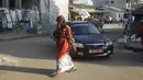 Seorang perempuan berjalan di sebuah jalan di Conakry, Guinea, Rabu (8/9/2021). Militer Guinea melakukan kudeta dan membubarkan pemerintahan serta konstitusi negara di Afrika Barat itu pada Minggu, 5 September lalu. (AP Photo/Minggu Alamba)