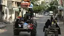 Sebuah traktor pertanian digunakan salah satu keluarga untuk keluar dari Shujayeh, (20/7/2014), menghindari serangan militer Israel ke Gaza, Palestina. (REUTERS/Mohammed Salem)