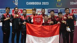 Tim bulu tangkis beregu putra Indonesia berpose memegang medali emas SEA Games 2023 setelah mengalahkan Malaysia pada laga final yang berlangsung di Badminton Hall Morodok Techo National Stadium, Phnom Penh, Kamboja, Kamis (11/05/2023). (Bola.com/Abdul Aziz)