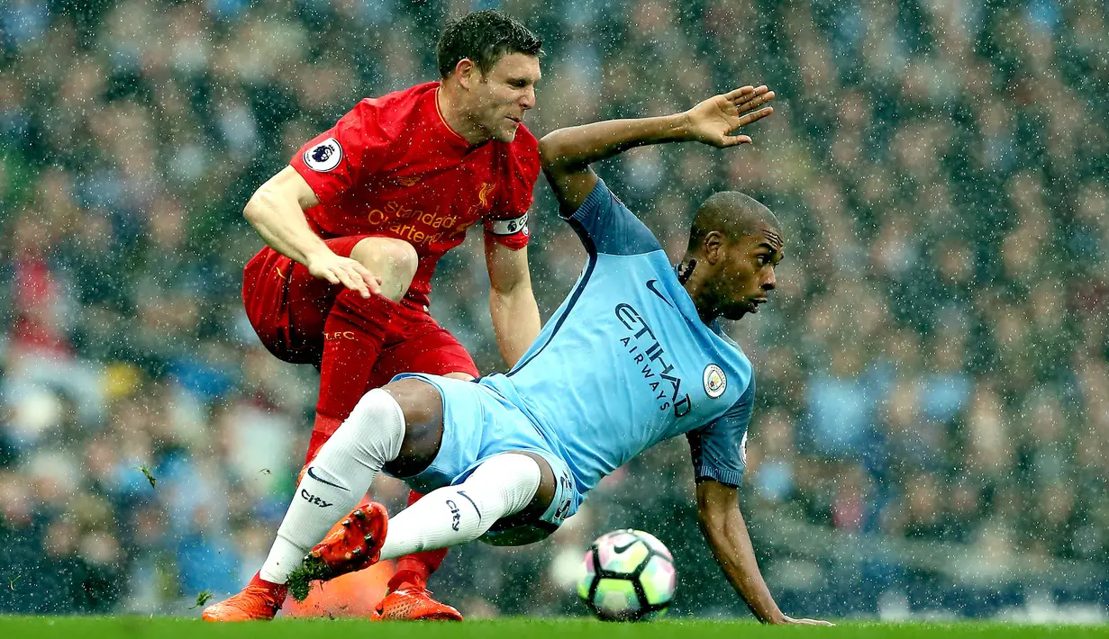 Gelandang Manchester City, Fernandinho, berebut bola dengan gelandang Liverpool, James Milner. Pada laga ini City turun dengan formasi 4-1-4-1, sedangkan The Reds memakai skema andalannya 4-3-3. (EPA/Nigel Roddis)