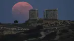 Bulan Purnama Stroberi atau Strawberry Full Moon muncul di belakang Kuil Poseidon marmer kuno di Cape Sounion, sekitar 70 Km selatan kota Athena, Yunani, Kamis (24/6/2021). Strawberry Full Moon adalah istilah yang diambil dari cerita tradisi dari suku-suku asli Amerika (AP Photo/Petros Giannakouris)