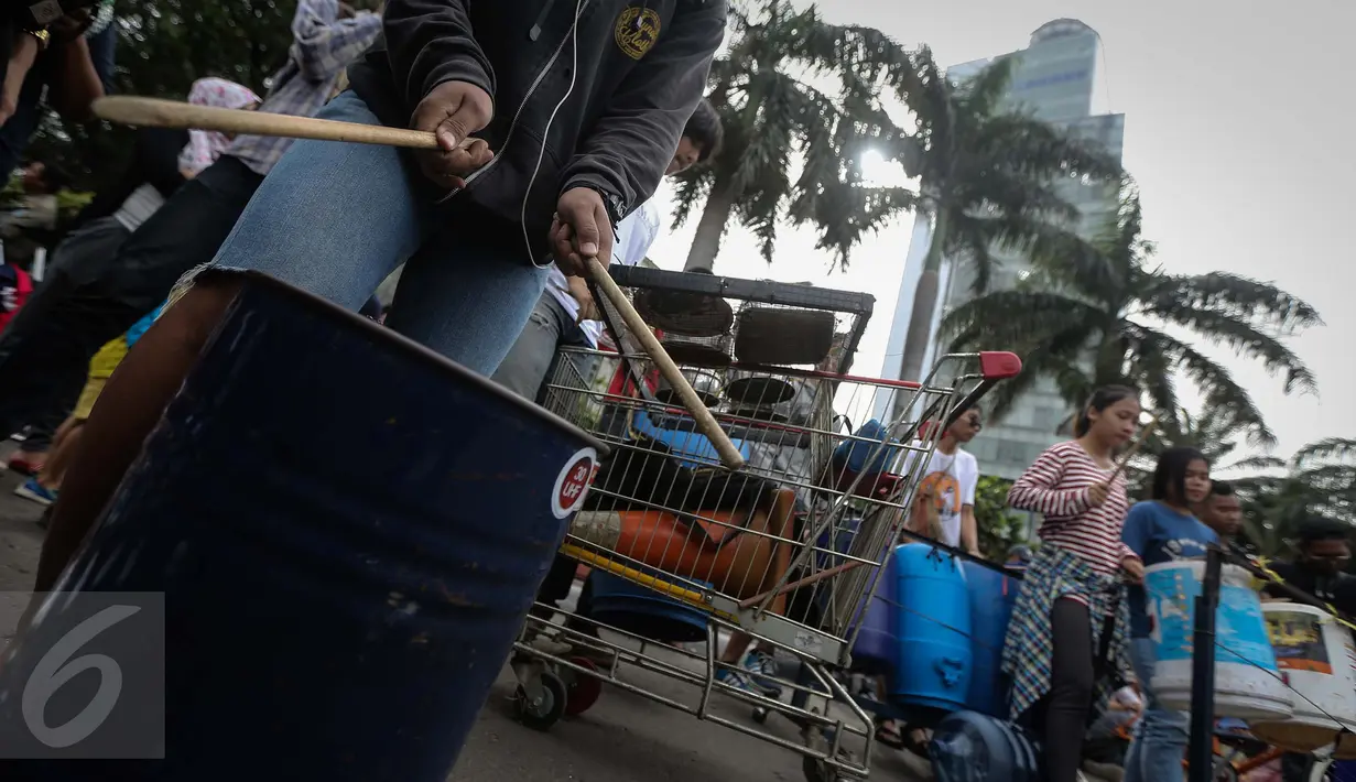 Atraksi pagelaran musik menggunakan barang-barang bekas di Car Free Day kawasan Bundaran HI, Jakarta, Minggu (15/1). (Liputan6.com/Faizal Fanani)