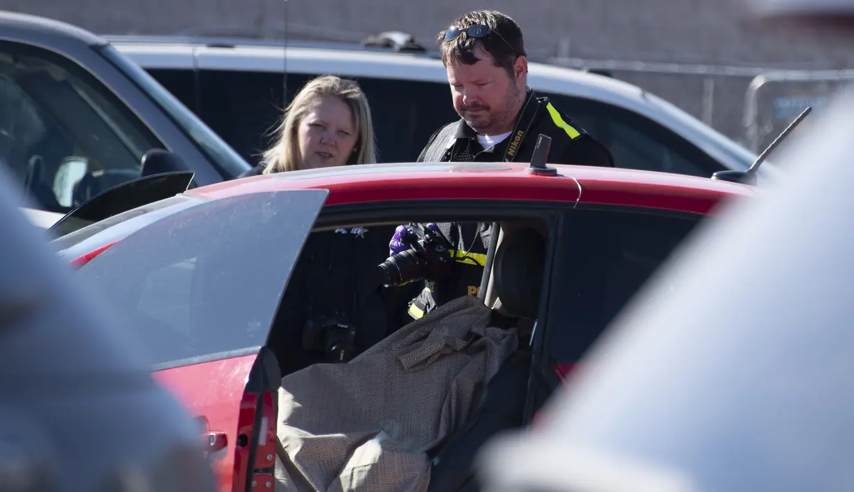 Polisi mengambil foto TKP setelah penembakan di tempat parkir Walmart, Duncan, Oklahoma, Amerika Serikat, Senin (18/11/2019 ). Kejadian tersebut menewaskan tiga orang, termasuk seorang pelaku. (J Pat Carter/Getty Images/AFP)