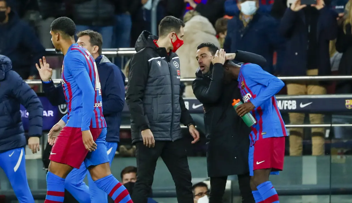 Penyerang Barcelona, Ousmane Dembele (kanan) diberi selamat oleh pelatihnya Xavi setelah mencetak gol ke gawang Athletic Bilbao selama pertandingan lanjutan La Liga Spanyol di di stadion Camp Nou di Barcelona, Spanyol, Senin (28/2/2022). Barcelona menang telak atas Atletico Bilbao 4-0. (AP Photo/Joa